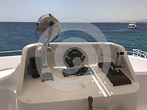 The captain`s cabin on a carboat, boat, cruise liner with a steering wheel, echo sounder, sea compass, navigator, gas grip, tacho