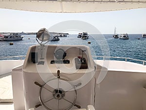 Captain`s cabin on a ship, boat, cruise liner with a steering wheel, dashboard, navigator, marine compass and control devices aga
