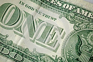 Caption: `one` and `in God we trust` on the one dollar bill. Cash, money