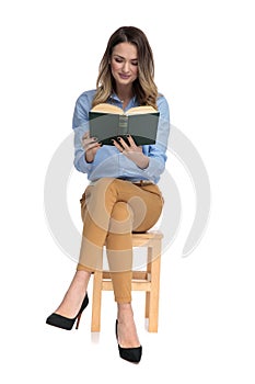 Captivated smart casual woman reading while sitting