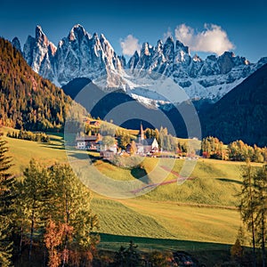 Captivating autumn view of Santa Magdalena village in front of the Geisler or Odle Dolomites Group.