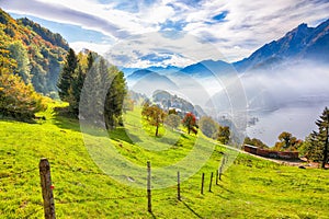 Captivating autumn view on suburb of Stansstad city and Lucerne lake with mountaines and fog