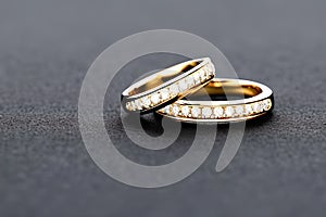 Captivating close up shot of two wedding rings, delicately intertwined to symbolize the everlasting bond of love and commitment.