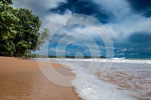 Captivating deserted beachscape with a radiant sun in a clear sky in Ghana, Africa