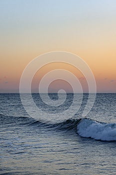 Captivating image of a calming sunset with a majestic ocean wave in the foreground