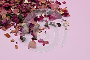 Dried rose petals on a pink background, purple rose flowers close-up, romantic floral texture