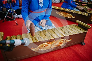 A captivating image of a young girl playing the enchanting tones of a traditional gamelan orchestra,