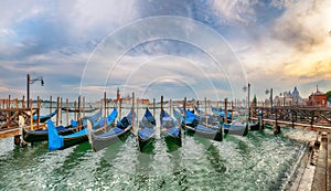 Captivating landscape with Church of San Giorgio Maggiore on background and gondolas parked beside the Riva degli Schiavoni in