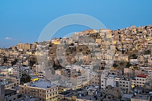 Captivating skyline of Amman, Jordan traditional houses atop a picturesque hill during blue hour