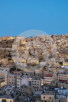 Captivating skyline of Amman, Jordan traditional houses atop a picturesque hill during blue hour