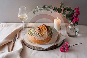 A Still Life Featuring Artisan Bread, Wine, and Delicate Floral Arrangements