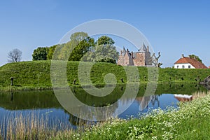 Captivating view across the moat water over the dike to Slot Loevestein Castle and its rich history. The fortress is the most