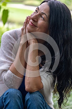 Captured in a moment of reflection, this image of a smiling woman could represent themes like mental well-being, the joy