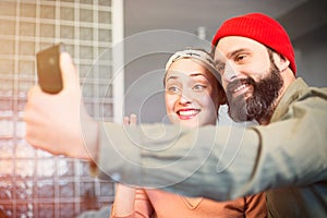 Capturing happy moments. Beautiful young loving couple bonding to each other and making selfie while sitting on the sofa