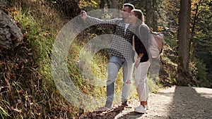 Capturing the moment. Loving couple of cheerful hikers taking selfie in the forest