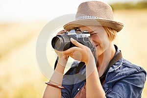 Capturing nature. An attractive young woman taking pictures of nature.