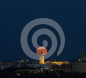 Capturing the Supermoon\'s Embrace in Seville\'s Skyline photo