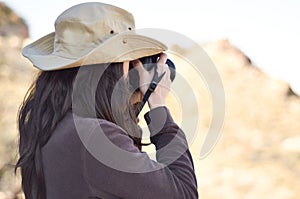 Capturing the wild. A young woman taking pictures outside.