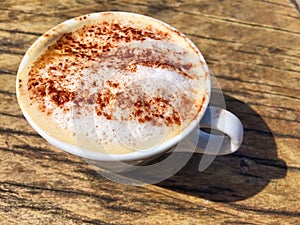 Capuccino coffee with chocloate sprinkles in the sunshine photo