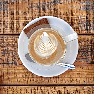 Capuccino cup on wooden background photo