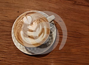 Capuccino on a wood table and white cup photo