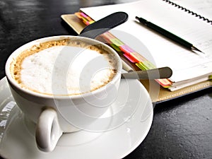 Capuchino coffee with notebook