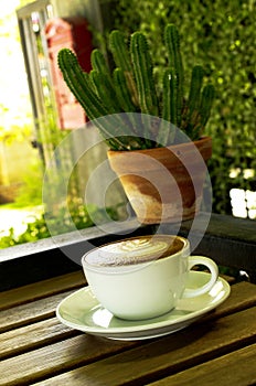 Capucino art coffee white cups and cantus pot on wood table