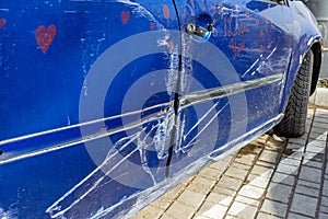 Car after accident, blue car crashed, accident,.Scratched doors, side of a blue female car with the words