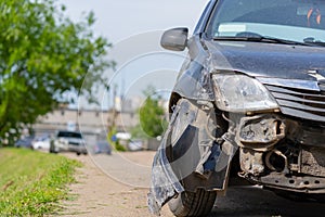 The car after the accident. Broken car on the road. The body of the car is damaged as a result of an accident. High speed head on