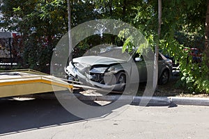 Car accident, head-on collision. Tow truck loads a wrecked car after an accident