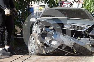 Car accident, head-on collision. Tow truck loads a wrecked car after an accident