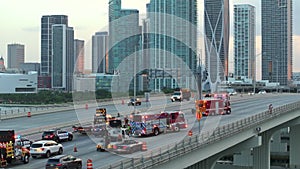 Car accident on highway bridge in Miami, Florida. Emergency services personnel helping victims of vehicle crash on city