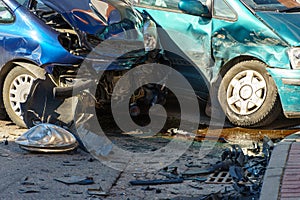 Car accident. Two crashed passenger cars are on the road after the accident. Various parts of the vehicle are lying on the road,