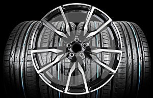 Car alloy wheel and tyre isolated on black background. New alloy wheel with tire for a car on a black background. Alloy rim isolat