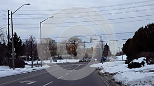 Car Approaches Stop Sign City Street Intersection and Turns Left.  Vehicle Driving Up to and Turning Left at Urban Road in Winter