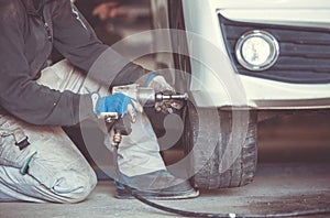 Car, auto mechanic changing tires, wheels on the car by pneumatic wrench, service center