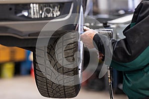 Car, auto mechanic changing tires, wheels on the car by pneumatic wrench, service center