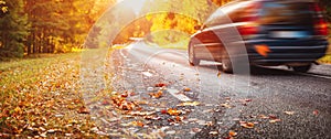 Car on the autumnal asphalt road in countryside