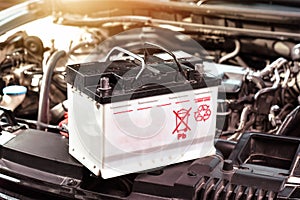 The car battery of the automobile electrical system in the engine compartment for car maintenance