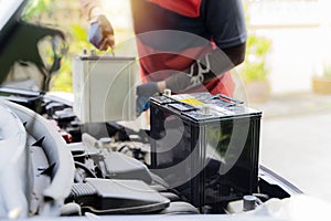 Car battery replacement. The car mechanic repairs the car, unscrews the battery mount