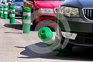 Car bending white and green safety traffic post with front bumper, wrong parking, car insurance, fine, penalty
