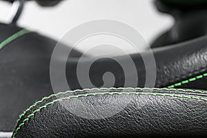 Car black leather interior. Part of leather car seat details with green stitching. Interior of prestige modern car. Comfortable pe