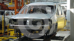 Car body on moving stand on conveyor during assembly of automobiles