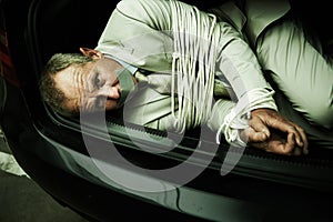 Car boot, hostage or portrait of business man with tape, rope and kidnap danger in parking lot. Fear, stress and face of