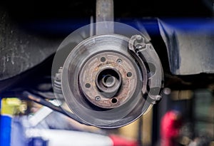 Car brake disk and caliper close up without wheel in cold colors