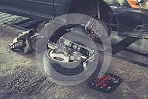 Car brake repairing in garage, Brakes on a car with removed wheel, car brake part at garage,car brake disc without wheels. old