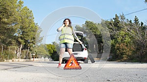 Car breakdown. Woman changing tire on a road