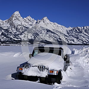 Car Buried in Snow in Winter with Teton Mountains in Background