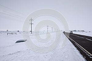 Car buried to its roof in deep snow not far from the road. North Dakota, USA