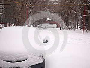 Car buried under snow after blizzard in residential area